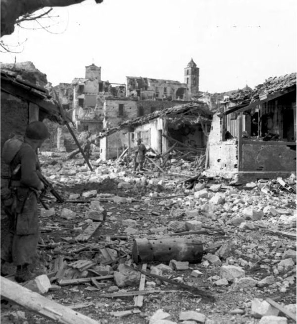 <p>12 gennaio 1944. Verso le 11 del mattino le prime pattuglie del II battaglione del 168th Infantry Regiment entrano in Cervaro, appena evacuata dai tedeschi. Nella didascalia originale si afferma che <i>“Il sergente Charles Russell copre il sergente Barney Wight alla ricerca di cecchini. Due uomini di questa pattuglia furono uccisi poco dopo.”</i></p><p class='eng'>INFANTRY PATROL ENTERING CERVARO on 12 January 1944. The man atleft is carrying a tommy gun and covering the two men in front as they hunt for snipers. A few minutes after this picture was made two men of this patrol were killed by Germans hidden in the ruins. Cervaro is on the western slopes of the Rapido Valley. By this time the Fifth Army had fought its way through the Winter Line mountains. Fighting in this area had lasted from 15 November 1943 to 15 January 1944.</p>