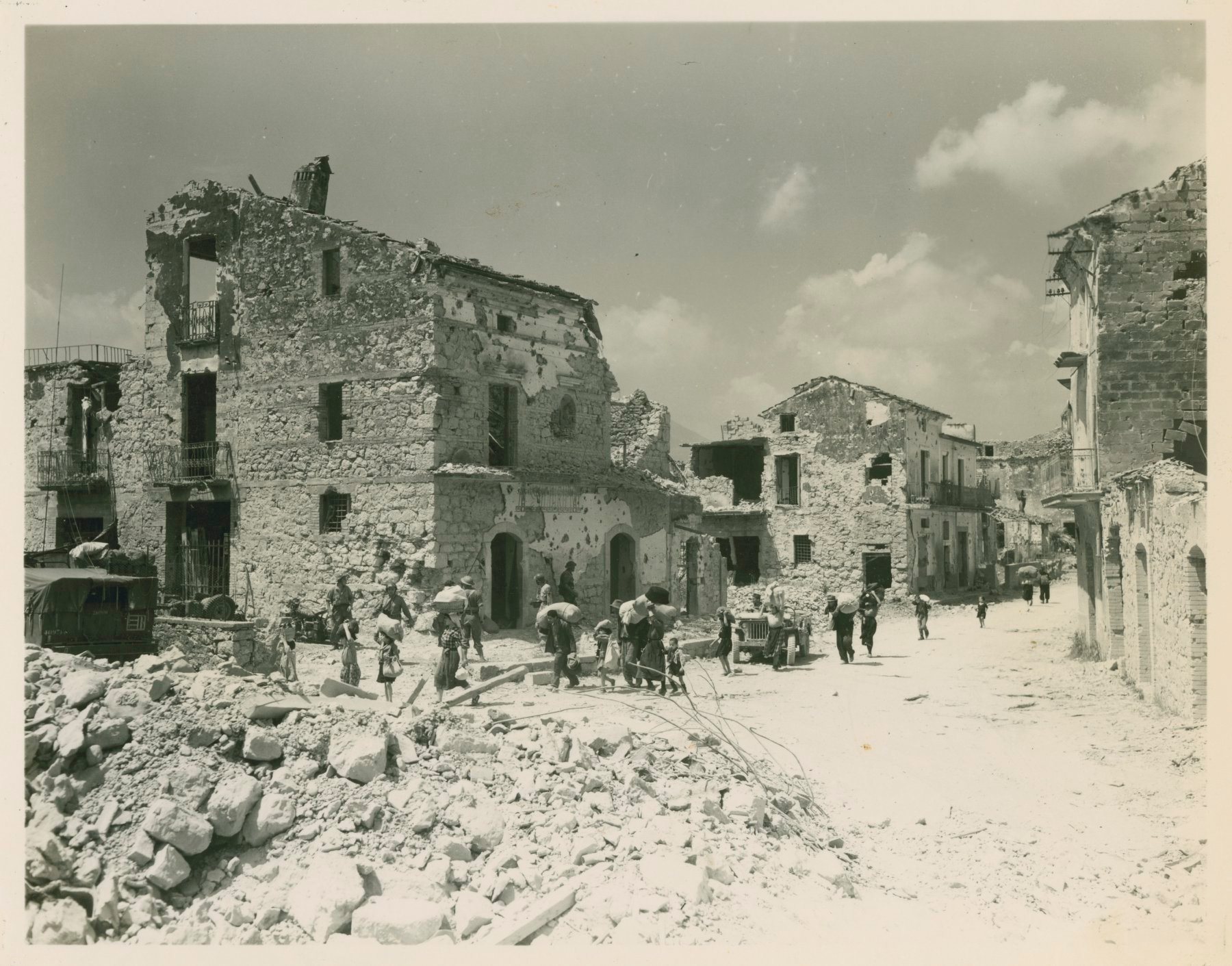 <p class='eng'>16 MAY 1944 – Fifth Army, St. Giorgio Area, Italy – 5-MM-44-5177 – Italian refugees making their way through St. Giorgio after the town fell to the 1st Motorized Infantry Division of the French Corps. (Photo by James A. Cuca, 163d Signal Photo Co.)</p>