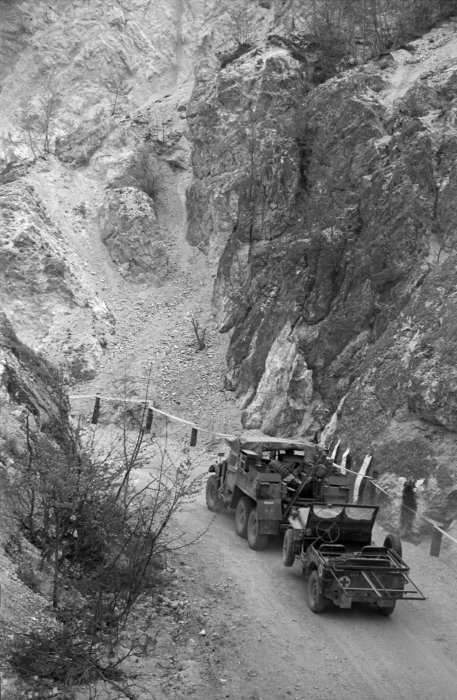 <p class='eng'>Military truck towing a jeep along the narrow roadway of the Inferno Track over which supplies are taken to the forward NZ troops in the Cassino area. Taken by G Bull in Italy, 29 April 1944.<br />Inscriptions: Inscribed - Backing board verso - top centre: Traffic making it's[sic] way along the narrow raodway[sic] of the Inferno Track over which supplies are taken to the forward NZ troops in the Cassino area.<br /><br />Bull, George Robert, 1910-1996. Military truck towing a jeep on the the Inferno Track, Cassino area, Italy. New Zealand. Department of Internal Affairs. War History Branch :Photographs relating to World War 1914-1918, World War 1939-1945, occupation of Japan, Korean War, and Malayan Emergency. Ref: DA-05606. Alexander Turnbull Library, Wellington, New Zealand. http://natlib.govt.nz/records/22729978</p>