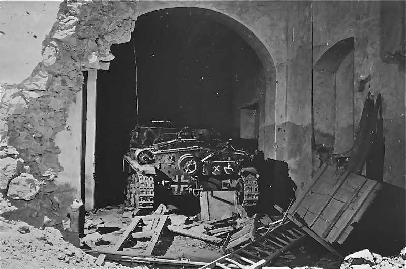 <p>18 maggio 1944. Un semovente italiano appartenente al Panzerjäger-Abteilung 71 abbandonato<br /> in una casa di Castelforte.</p><p class='eng'>German tank in cellar of house on back street in Castelforte, Italy. This tank didn't get<br /> into action due to the surprise element of the opening barrage. Fifth Army, Castelforte Area,<br /> Italy. 18 May 1944. (5/18/1944). National Archives and Records Administration, College Park,<br /> Maryland (111-SC-189944).</p>