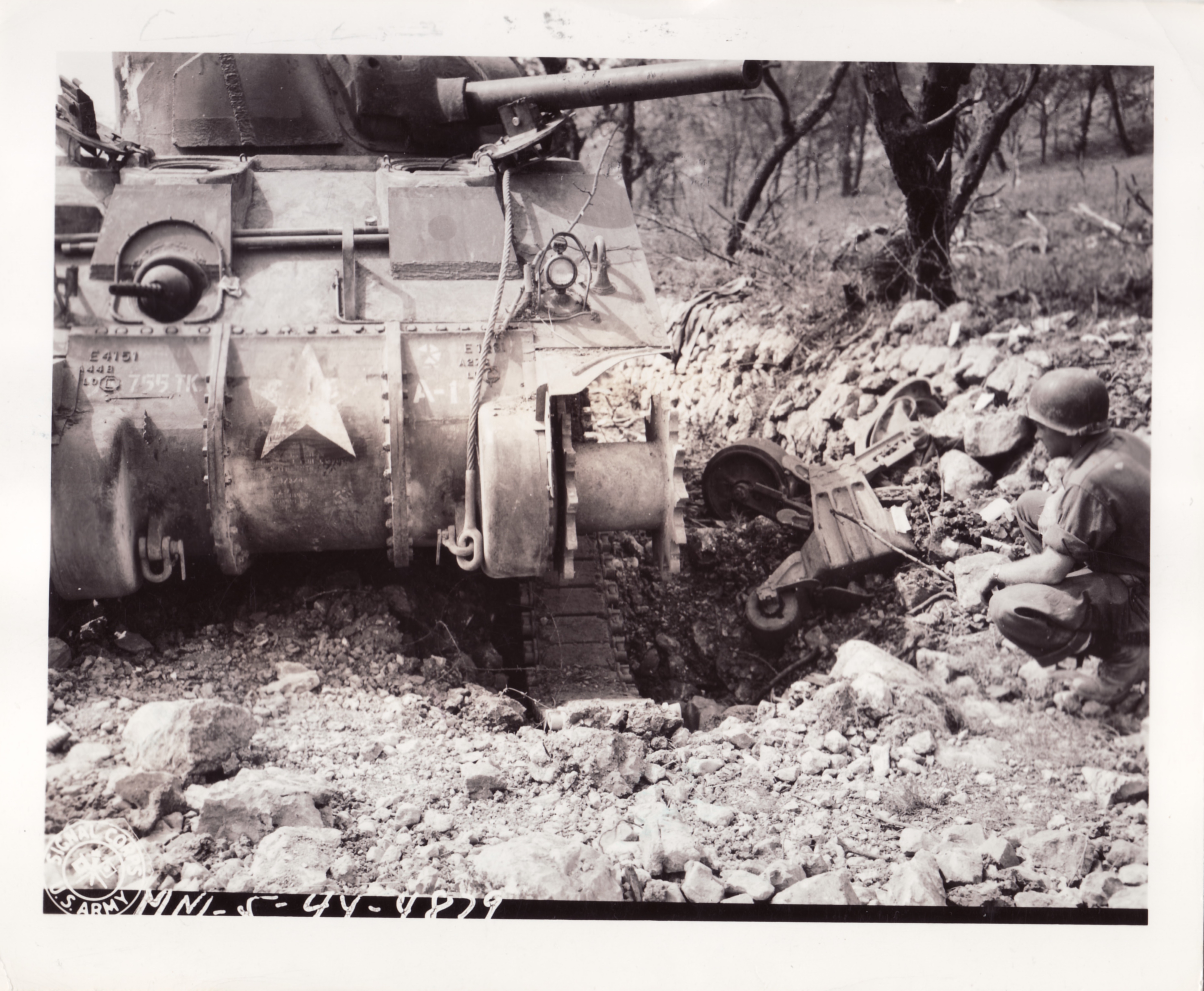<p class='eng'>13 MAY 1944 MM-5-44-4879<br />FIFTH ARMY CASTLEFORTE AREA, ITALY<br />MEDIUM TANK TREAD BLOW OFF BY MINE.<br />SOLDIER IS SGT. MAX CAMPBELL (LOS ANGELES, CALIF.) APS. PHOTOGRAPHER.<br />PHOTO BY ROONEY<br />163RD SIGNAL PHOTO CO.<br /><br />Note - Campbell, who saw combat during the Sicilian Campaign, was later reassigned to the 3131st Signal Service Co. He died of wounds in October 1944 in the town of Monghidoro (from "The Last Farewell - A Journey of the Heart").</p>