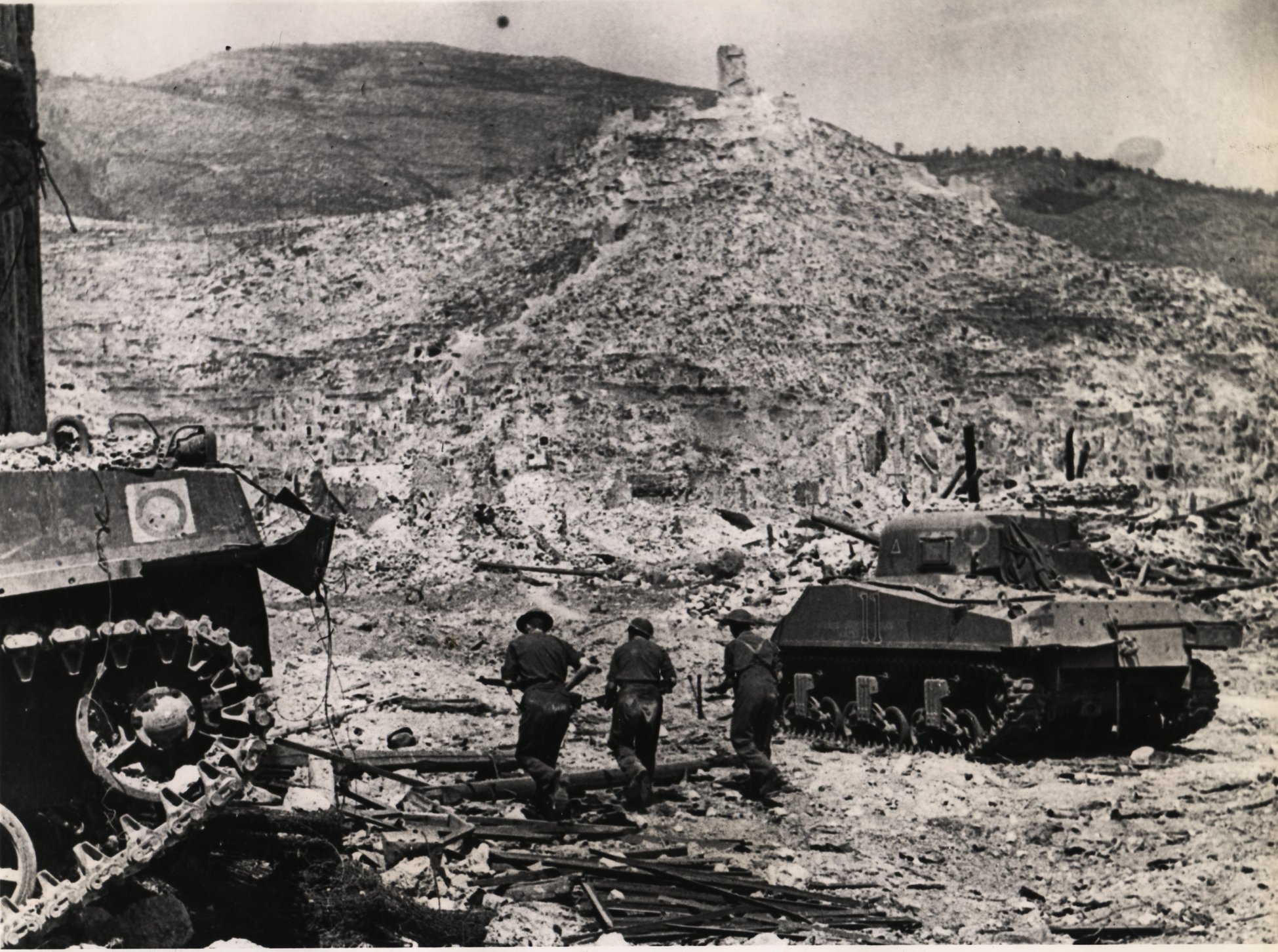 <p class='eng'>Sherman tanks and infantry in the ruins of Cassino, 18 May 1944. McConville (Sgt).<br /> ©IWM<br /> (NA 15009)</p>