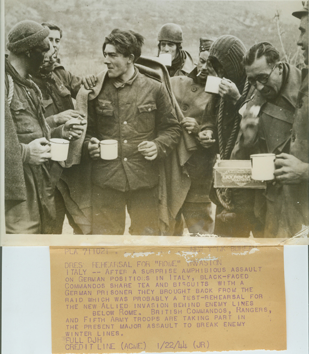 <p class='eng'>NEW YORK BUREAU DRESS HRHEARSAL FOR “ROME” INVASION ITALY - After a surprise amphibious assault on German positions in Italy, black-faced Commandos share tea and biscuits with a German prisoner they brought back from the raid which was probably a test-rehearsal for the new Allied invasion behind enemy lines below Rome. British Commandos, Rangers, and Fifth Army troops are taking part in the present major assault to break enemy winter lines. Credit: Acme.</p>
