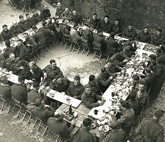 <p>Ortona, 25 dicembre 1943, il pranzo di Natale dei soldati canadesi.</p><p class='eng'>In the decades after the Second World War, a photograph emerged that became a symbol for the battle of Ortona. On December 25th, just blocks from the front line, men rotated back for a shared Christmas dinner then returned just as quickly to the fighting, many killed only moments later. A rare photo of the Christmas dinner being served to the troops became a symbol of civility amidst the horrors of war. It also served as a Regimental icon of the Seaforth Highlanders’ remarkable experience in the Church of Santa Maria di Constantinopoli on Christmas Day, 1943.<br />From: https://www.seaforthhighlanders.ca/stories/472</p>